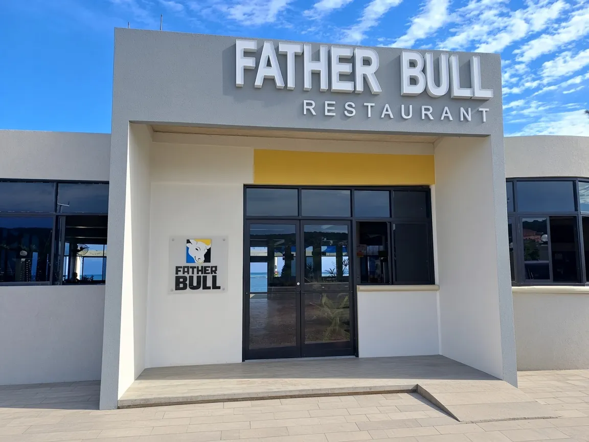 The Father Bull restaurant building, its name lettered above a glass entrance under a clear sky