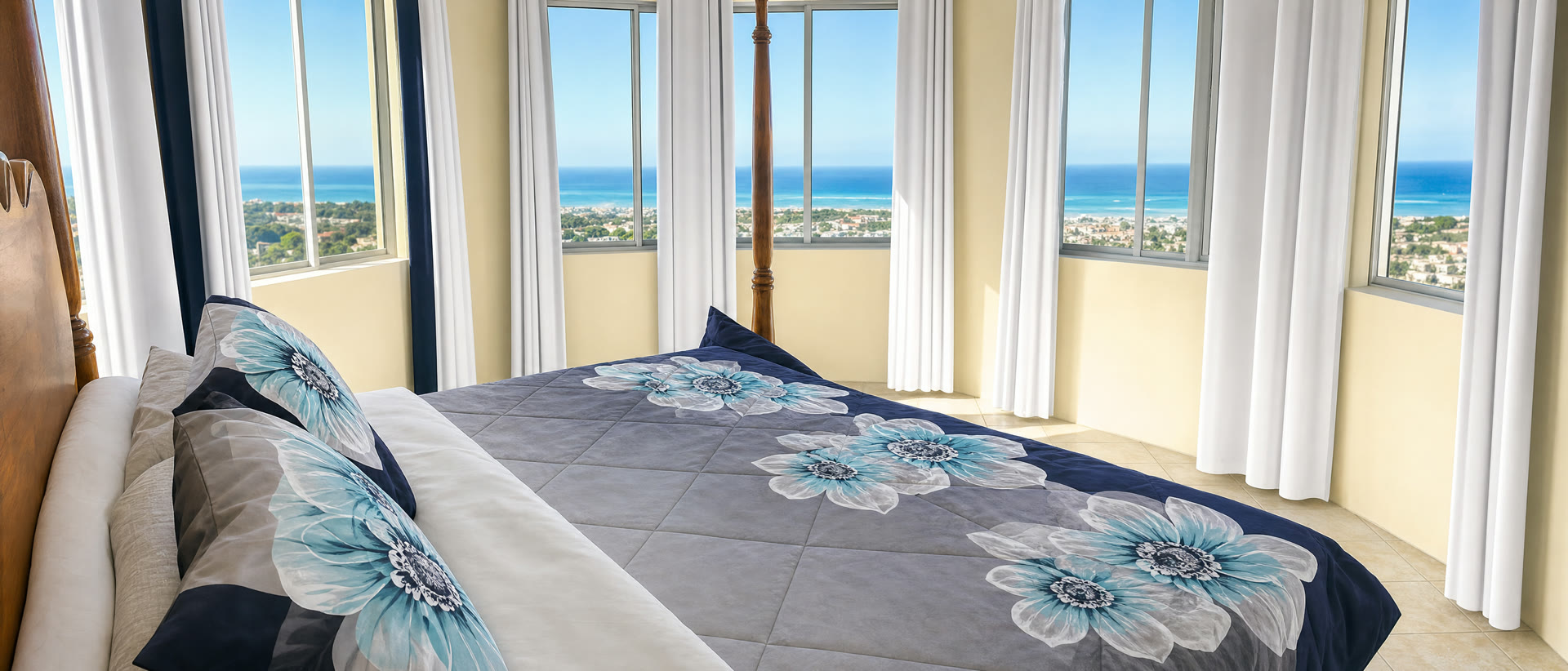 The Ocean Suite — a four-poster bed facing panoramic windows full of sea