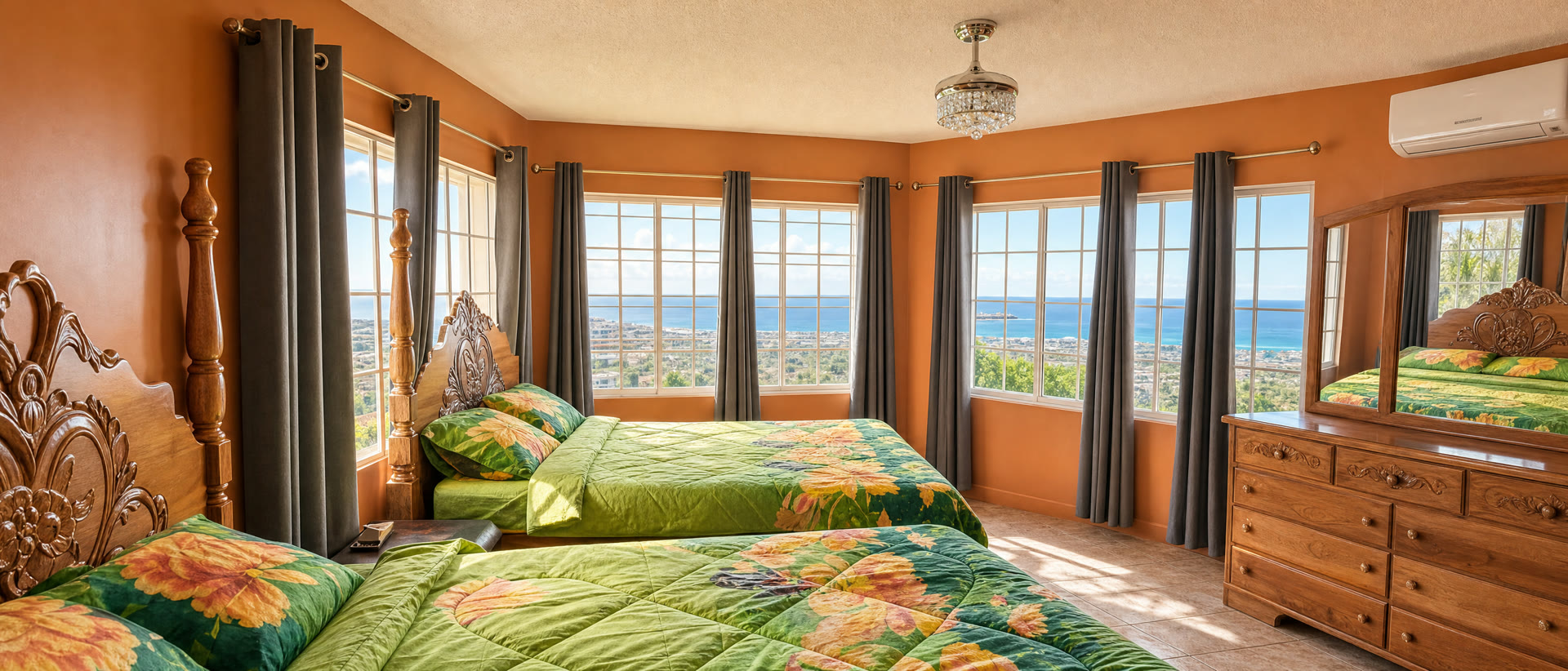 Garden Suite interior — two beds against warm orange walls, ocean-view windows
